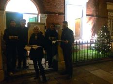 The staff giving mulled wine, hot chocolate & Christmas treats to passers outside the office this week